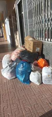 Bolsas de ropa depositadas fuera del horario de recogida de Zafra Solidaria y aviso para respetar las normas de donación.